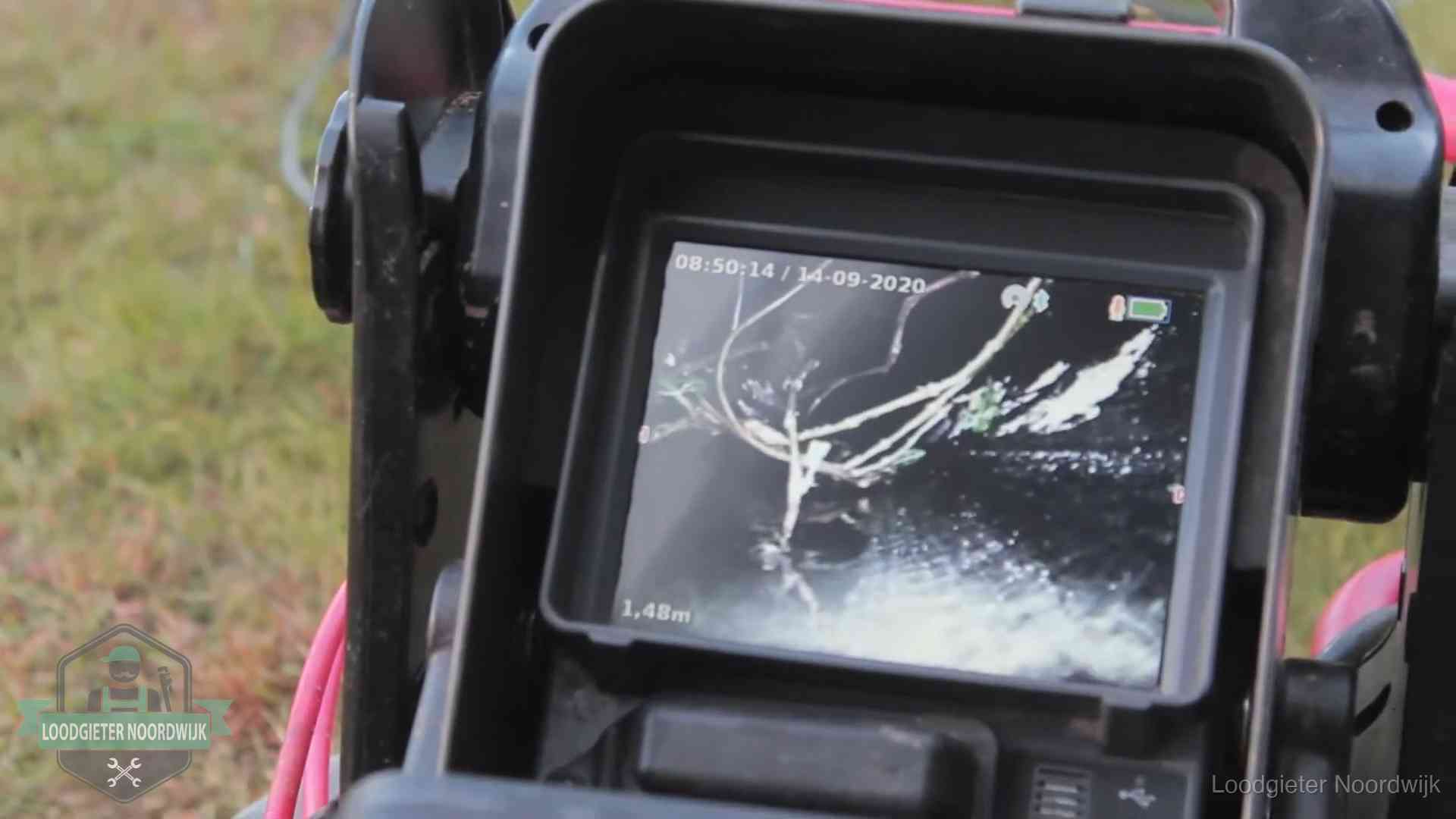 Monitor van een rioolcamera toont wortelingroei in de rioolbuis bij een woning in Noordwijk