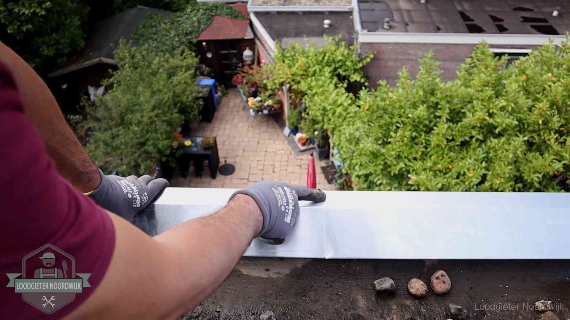 Daklekkage geregeld in Noordwijk Vakman plaatst een daktrim op de dakrand van een woning in Noordwijk