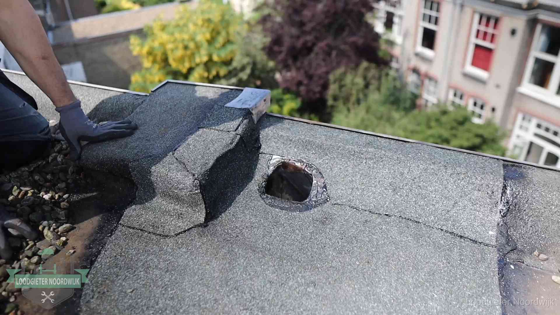 Daklekkage-inspectie op een plat dak in Noordwijk Loodgieter inspecteert een beschadigd bitumen plat dak tijdens een daklekkage-inspectie in Noordwijk