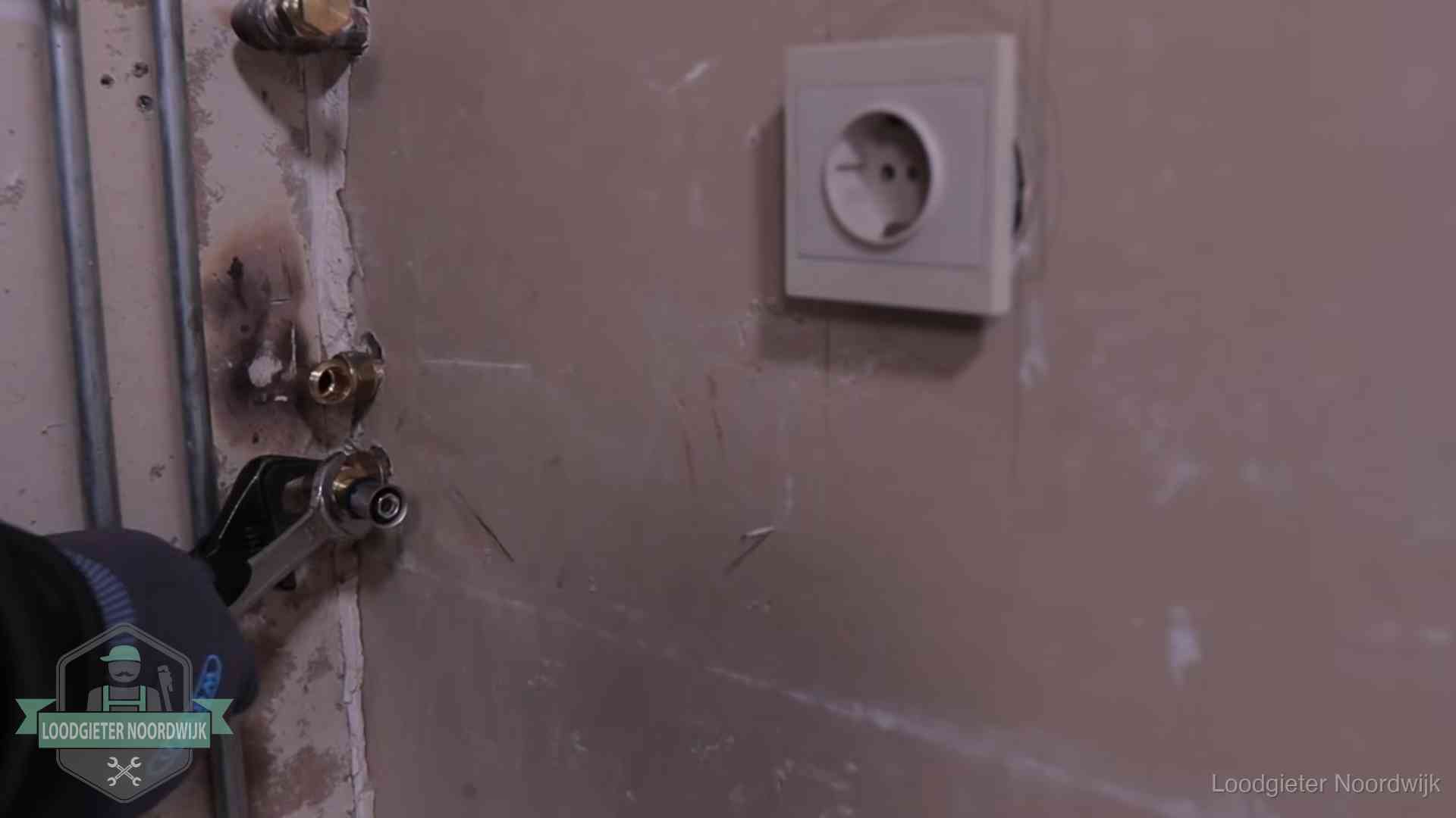 Monteur draait een perskoppeling vast op een leidingaansluiting in Noordwijk