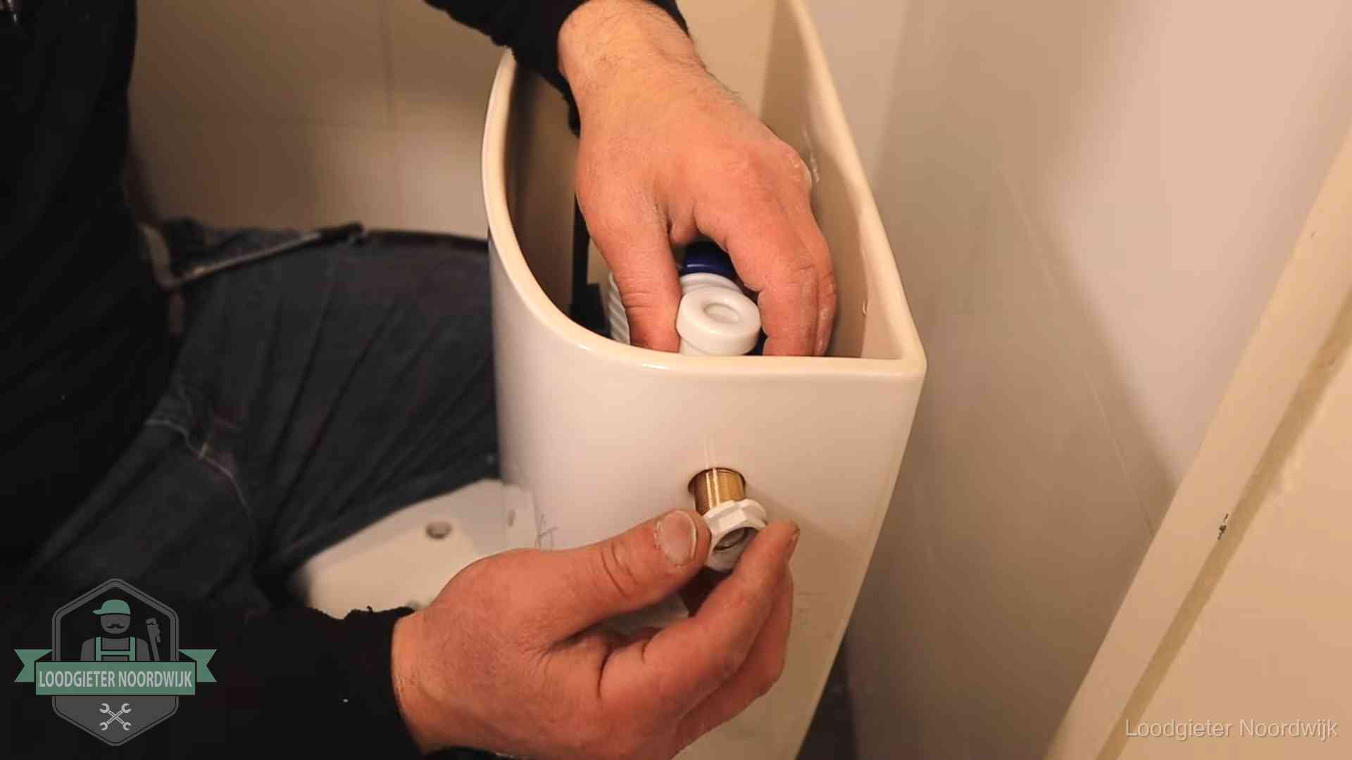 Loodgieter voor je verstopte wc in Noordwijk Loodgieter monteert de vlotterkraan van een stortbak bij een toilet in Noordwijk