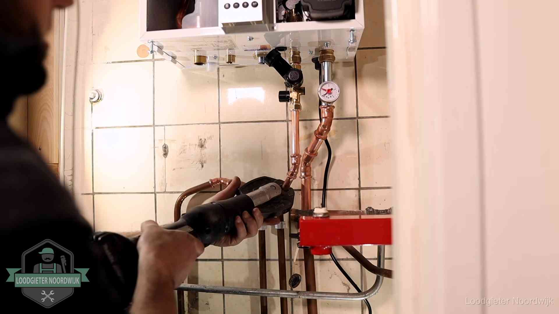 Cv-ketel onderhoud in Noordwijk Monteur werkt aan de leidingen onder een cv-ketel in Noordwijk