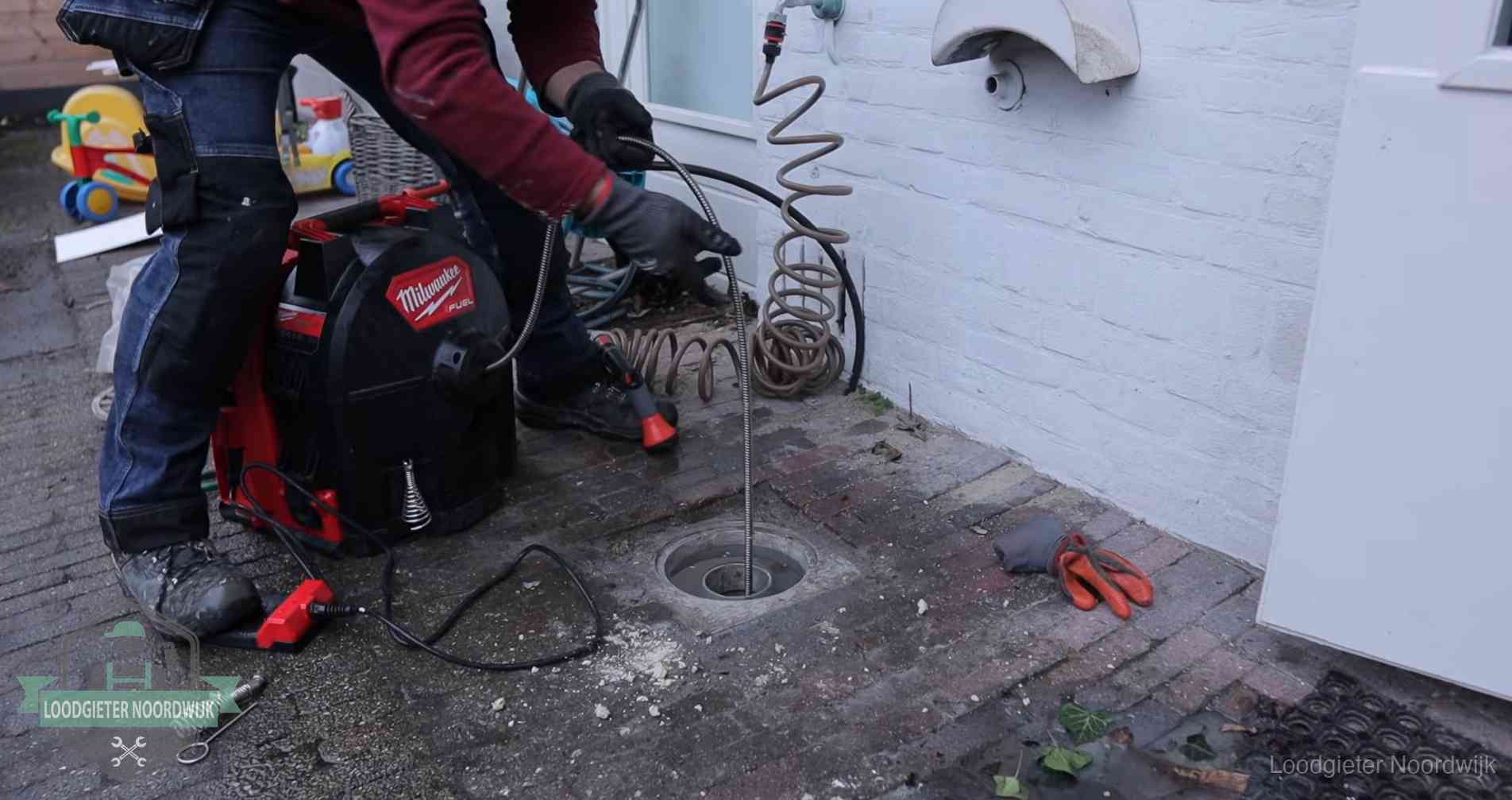 Ontstoppingsputje in de bestrating naast de gevel van een woning in Noordwijk
