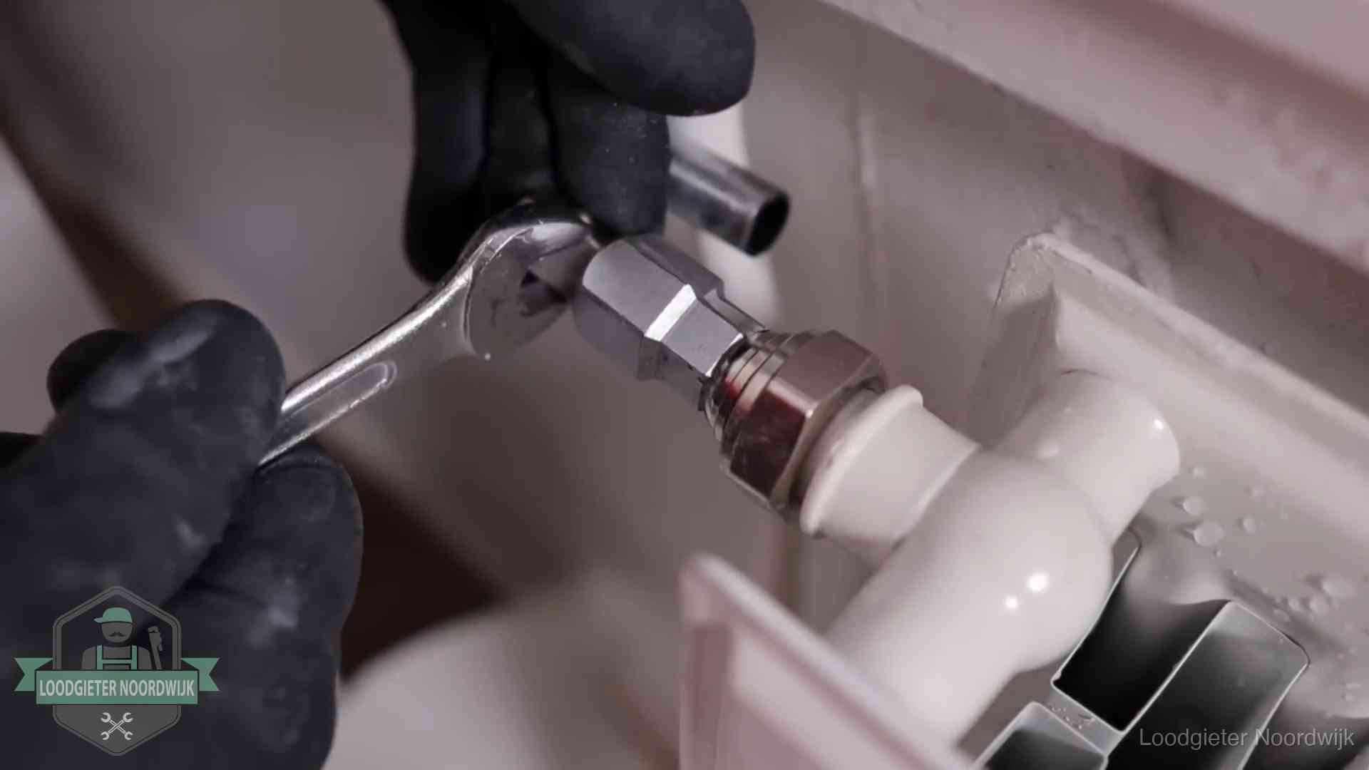 Radiatoren en waterzijdig inregelen in Noordwijk Steeksleutel draait een wartelkoppeling op een radiatorkraan aan in Noordwijk