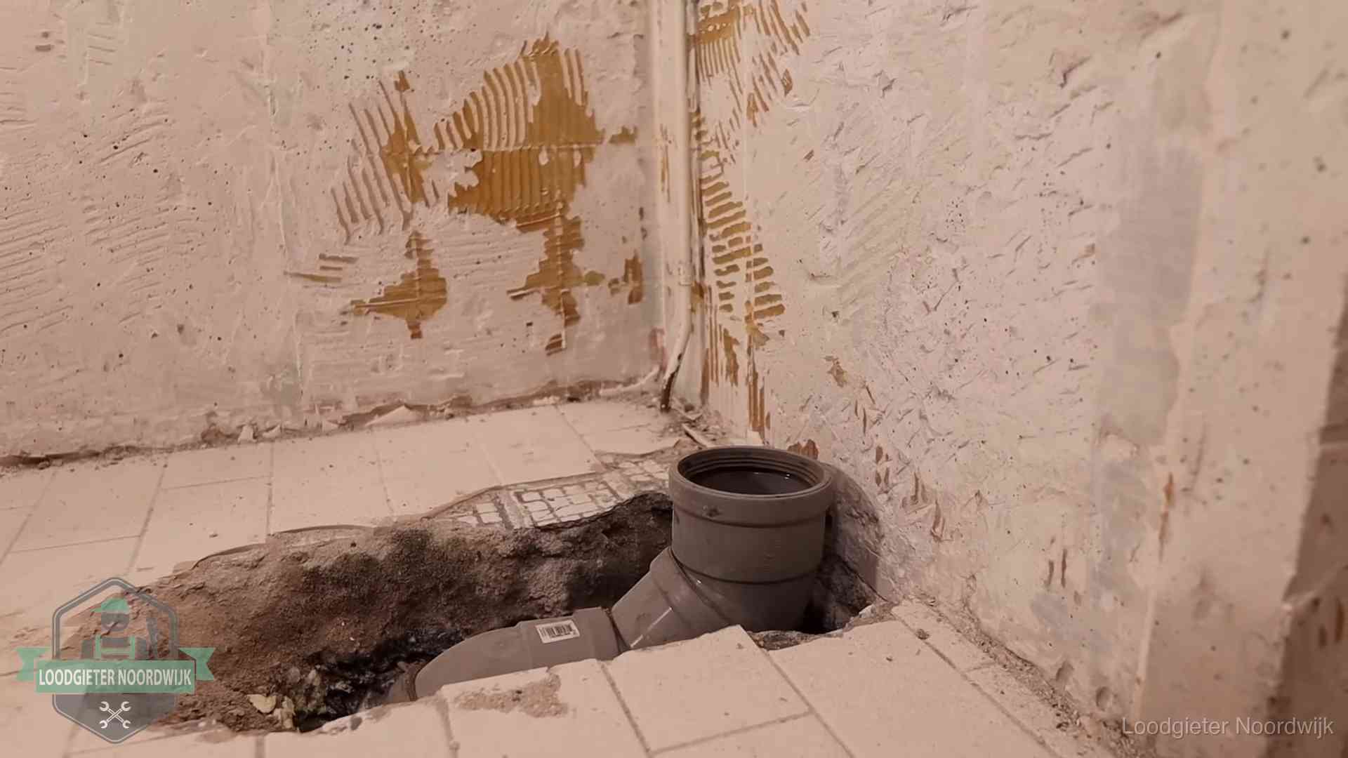 Opengebroken vloer met een nieuwe pvc-rioolbocht in een gegraven sleuf in Noordwijk