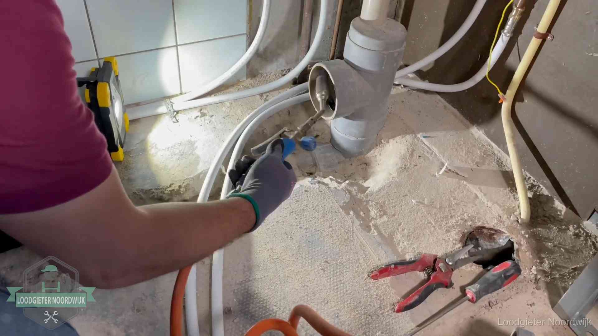 Loodgieter werkt aan leidingen bij een pvc-standleiding in een appartement in Noordwijk