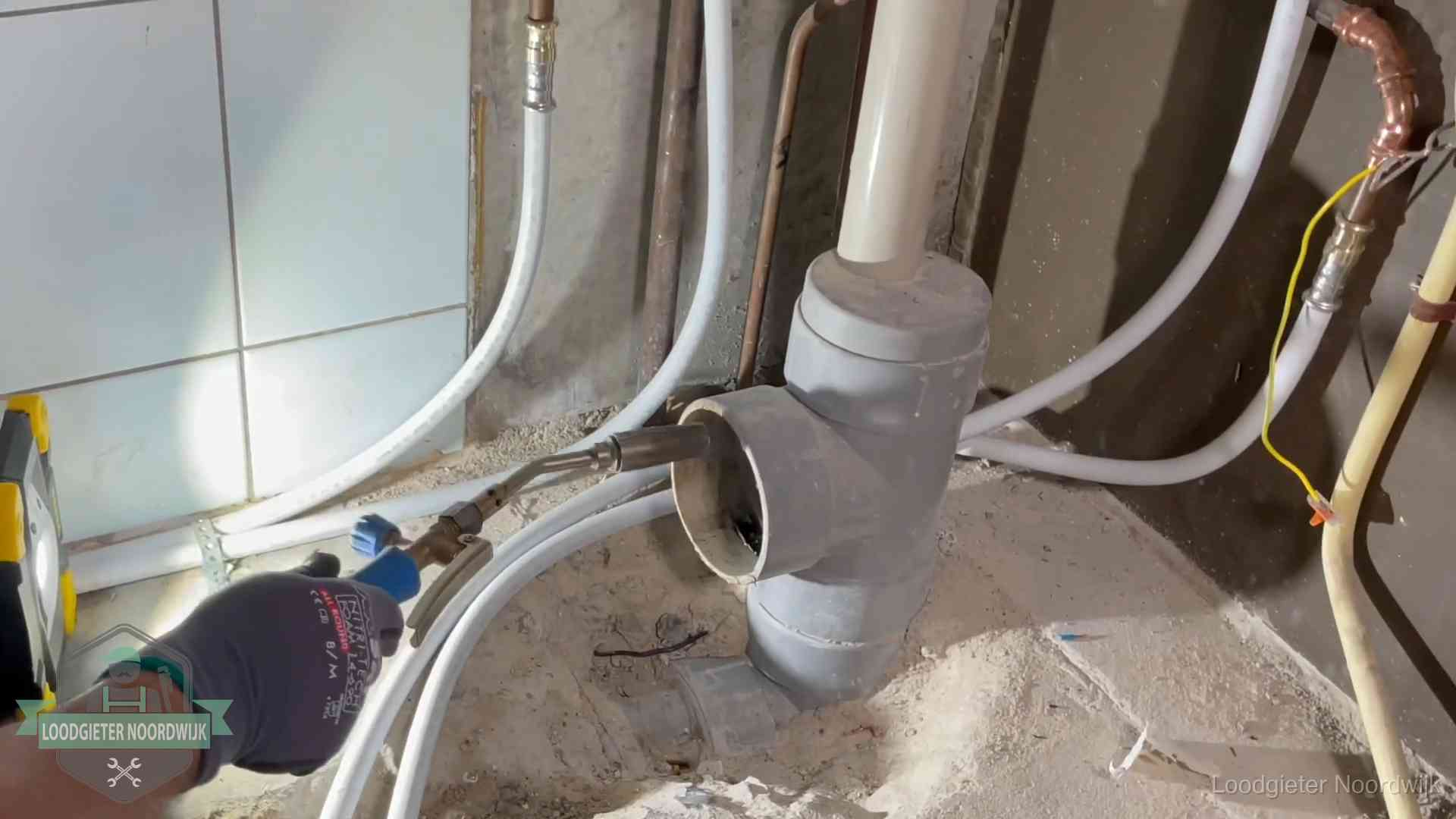 Loodgieter werkt aan leidingen bij de pvc-standleiding van een huurwoning in Noordwijk