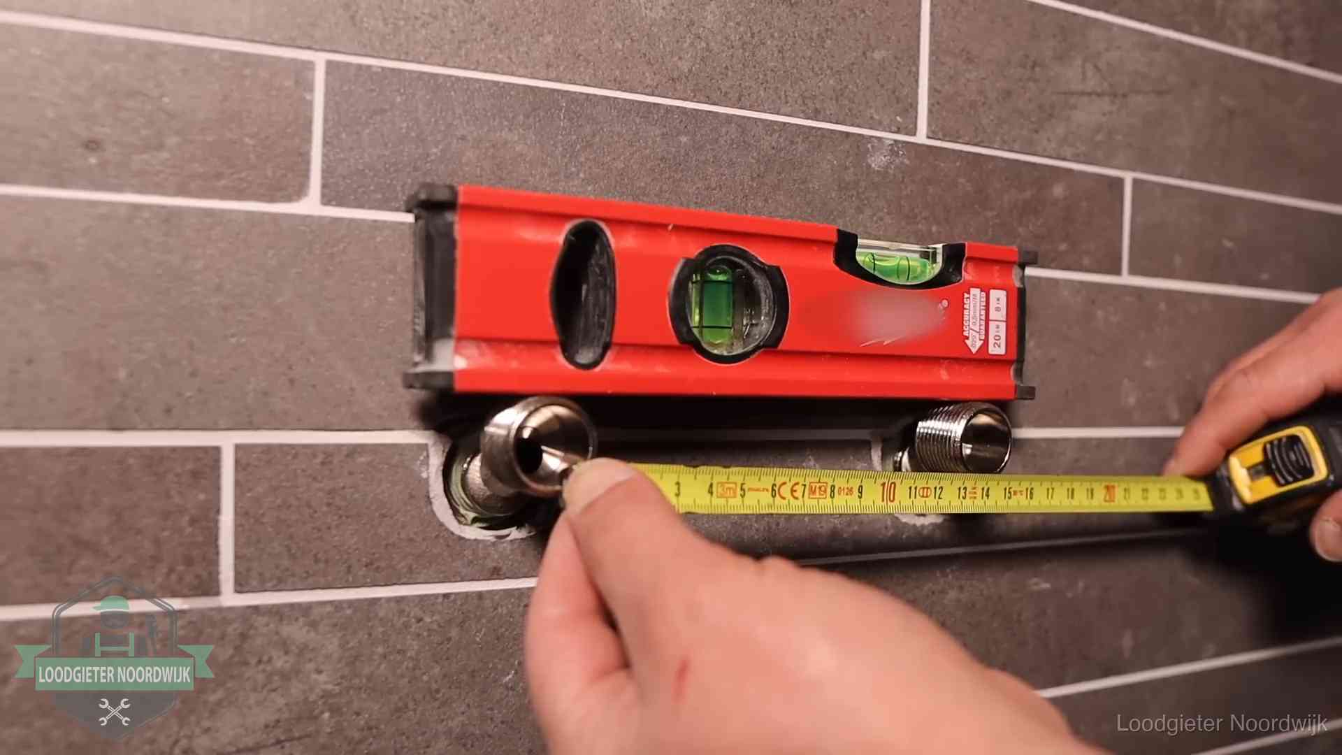 Waterpas en duimstok bij kraan-aansluitpunten in een badkamer in Noordwijk