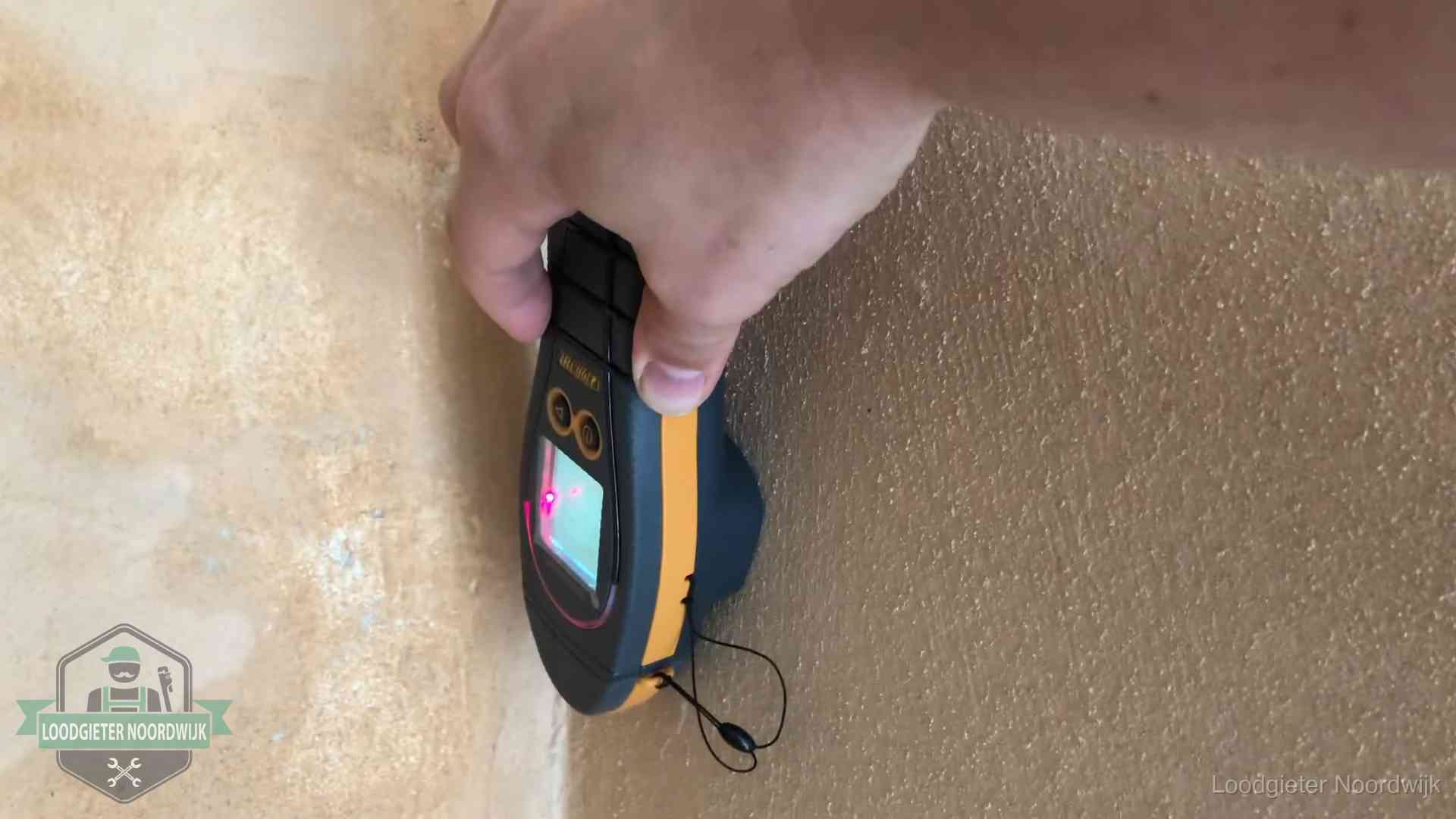 Daklekkage opsporen zonder hakwerk in Noordwijk Vochtmeter tegen een muur met vochtplekken tijdens het opsporen van een daklekkage in Noordwijk