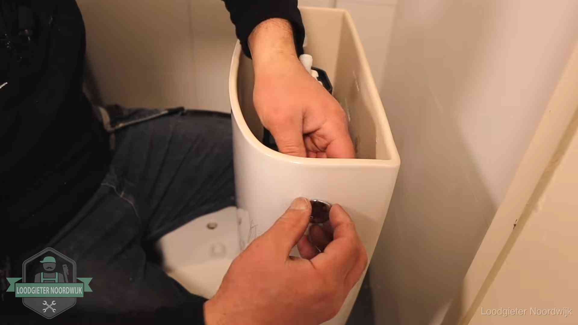 Je wc verstoppingsvrij houden in Noordwijk Drukknop van een duoblok-stortbak wordt gemonteerd bij een toilet in Noordwijk