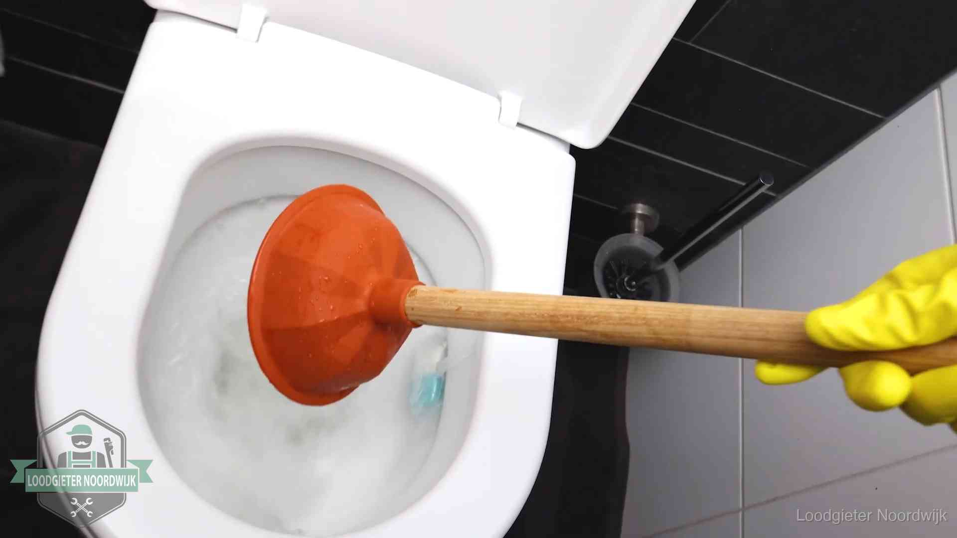 Wc ontstoppen met de plopper in Noordwijk Plopper wordt in de wc-pot gedrukt bij het ontstoppen van een toilet in Noordwijk