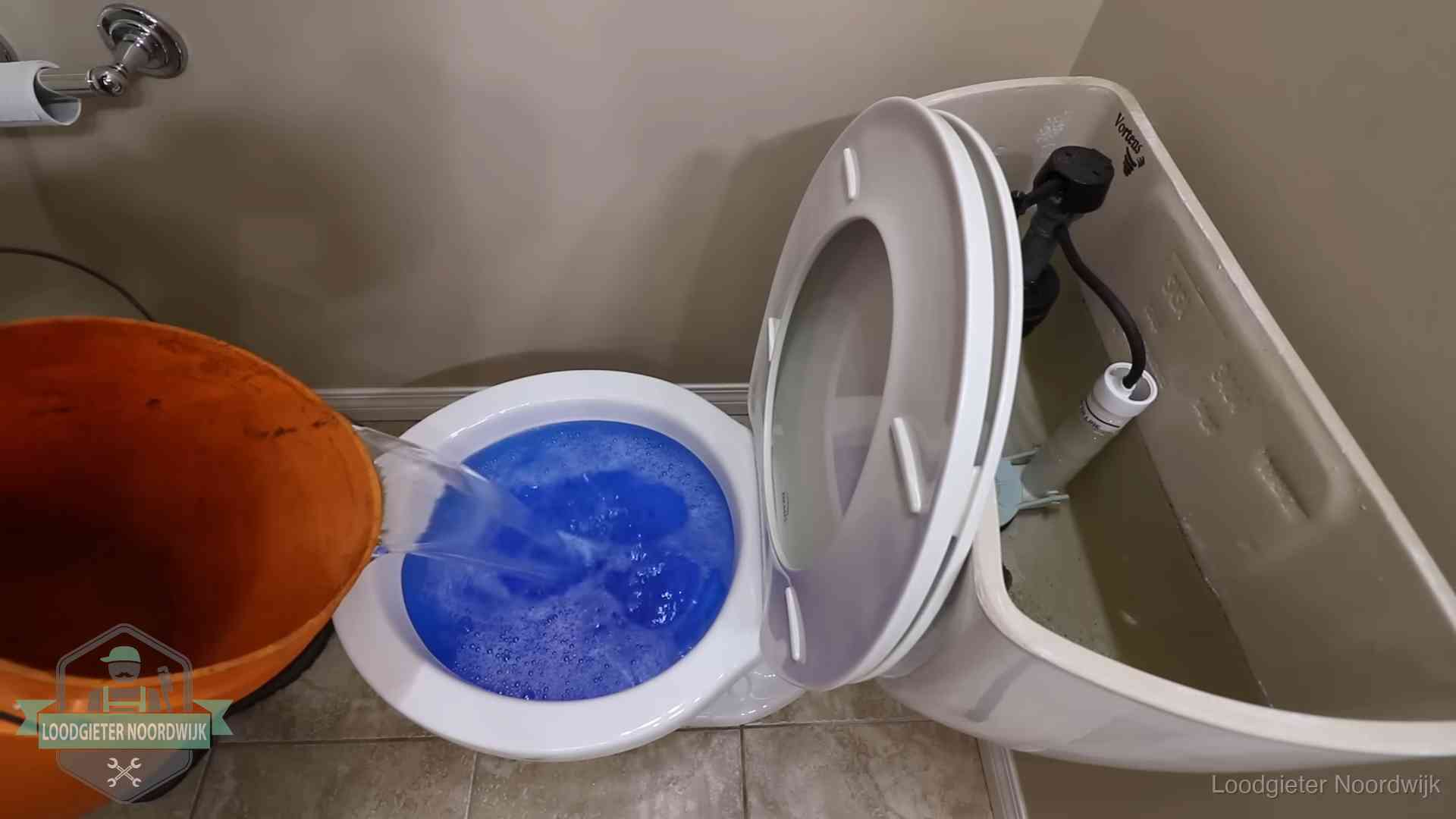 Water komt omhoog in de wc in Noordwijk Water bij de wc-pot wordt met een emmer weggewerkt om schade te beperken in Noordwijk